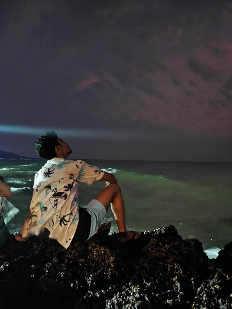 Ranga sitting by the sea at night